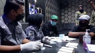 Petugas gabungan melakukan test urin kepada pengunjung karaoke
